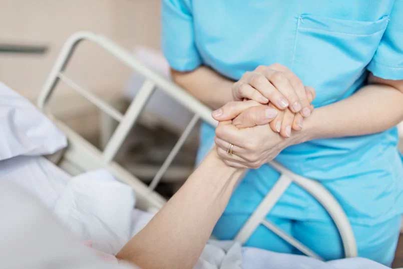 nurse holding patients hand